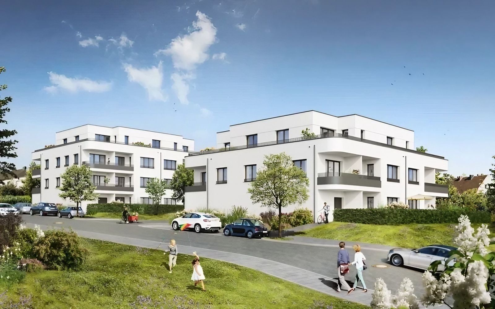 Moderne Mehrfamilienhäuser mit weißen Fassaden in ruhiger Wohngegend an einer begrünten Straße